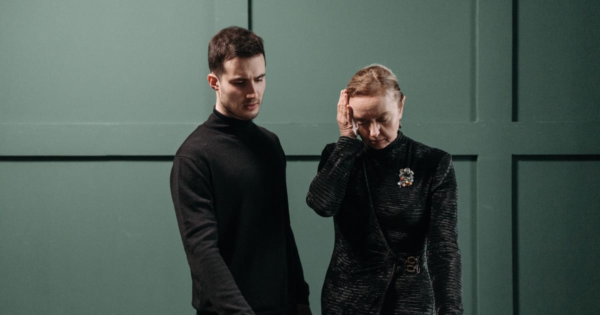 A solemn moment shared between a man and woman at a funeral, symbolizing loss and mourning.