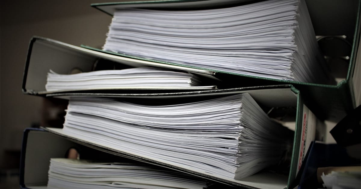 Close-up of stacked binders filled with documents for office or educational use.
