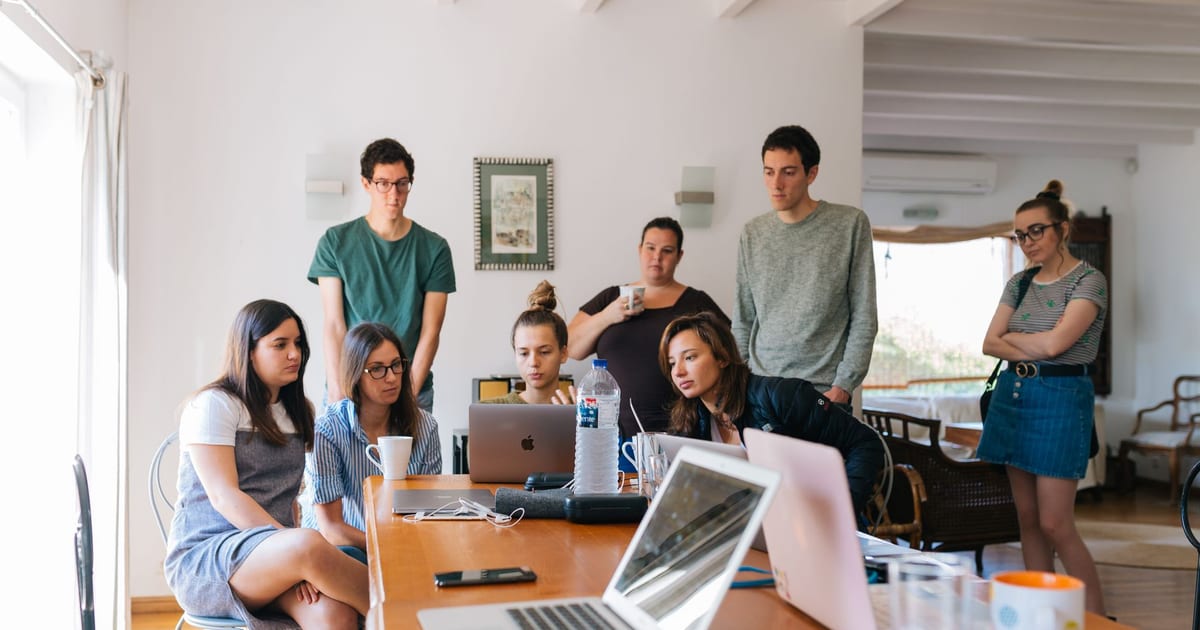 Group of young professionals engaged in a collaborative meeting in a modern office setting.