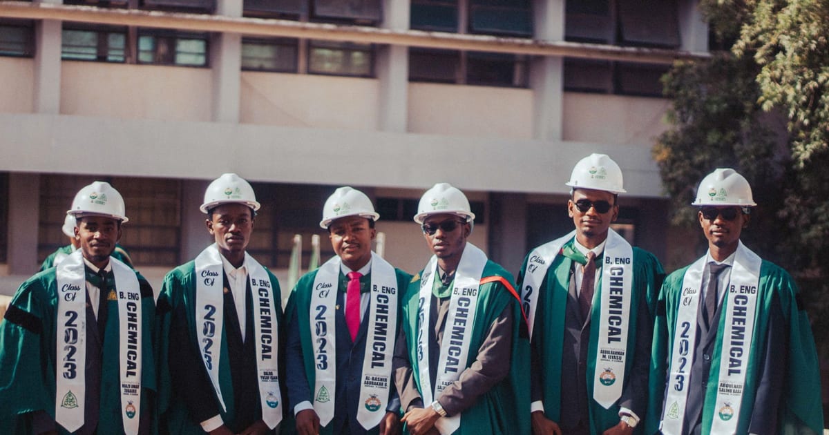 Graduates in caps and gowns celebrating chemical engineering degrees outdoors.