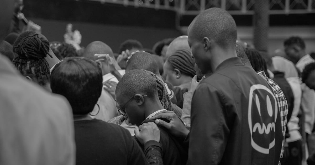 A black and white photo capturing a group of people gathered closely in a public space.