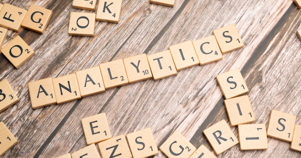 Scrabble tiles spelling 'Analytics' on a wooden surface, symbolizing data analytics concept.