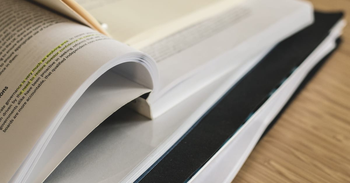 A pile of open books on a table, ideal for study and research themes.