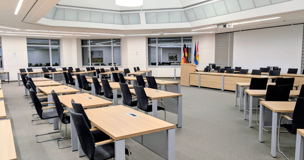Spacious and modern meeting room in Niedersachsen, Germany, with desks and flags.