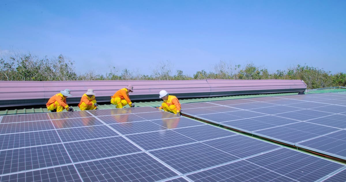 Workers installing solar panels on a sunny day, promoting renewable energy and sustainability.