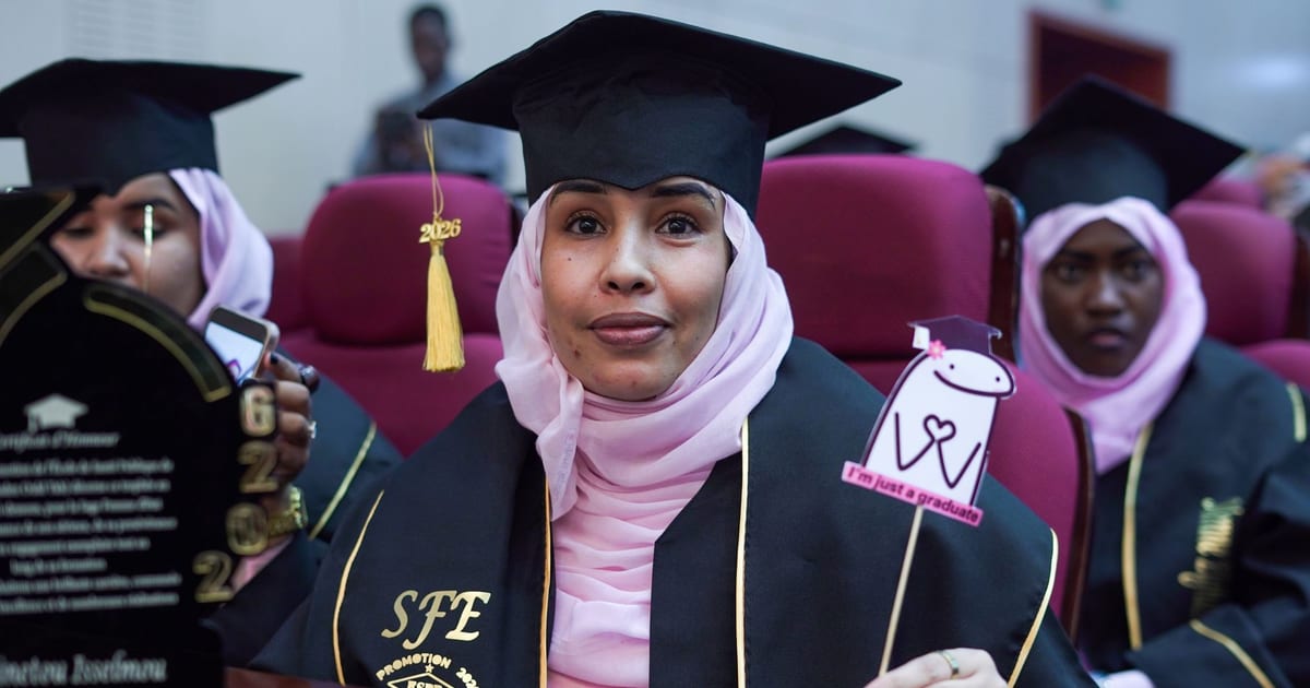 Graduates in hijabs celebrating at a ceremony, wearing caps and gowns.